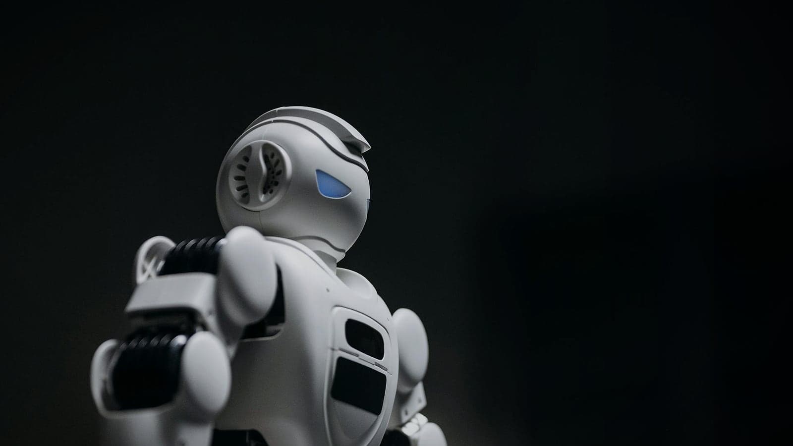 White robot standing against a dark background, representing the Whaleer automated trading bot ecosystem.